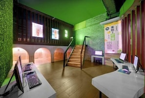 A modern interior with a wooden staircase, green walls, and multiple computer stations. - Jinlongtan jiudian (Zhaodong)