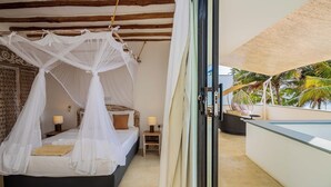 A bedroom with a four-poster bed, a nightstand with a lamp, and a view of the outdoors. - Ahadi Beach Villa, beautifully modern with pool beach access fantastic sea views (Mtwapa)