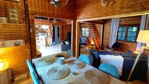 Interior acogedor de una cabaña de troncos con comedor, sala de estar y cocina.