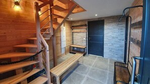 Ein modernes Interieur mit einer Holztreppe, einer Bank und einer Tür.