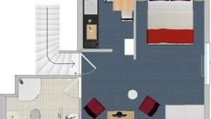A hotel room layout with a bed, a desk, a chair, a bathroom, and a small seating area. - APARTMENT 2 ON THE 2ND FLOOR (Norderney)