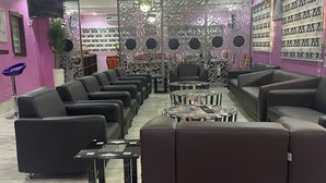 A modern lounge area with leather sofas, a coffee table, and decorative panels. - Farik Hotels and Suites  (Ibadan)