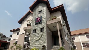 A building with a stone facade, a sign reading "FARIK BATH & SUITES," and potted plants around the entrance. - Farik Hotels and Suites  (Ibadan)