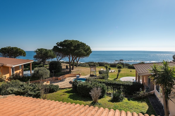 Una propiedad costera con piscina, patio y vistas al mar.