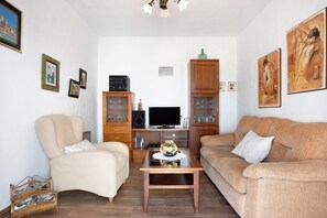 A living room with two sofas, a coffee table, a television, and a cabinet. - Vacation Home "Las Niñas" with Sea View, Private Terrace & Garden (Vejer de la Frontera)