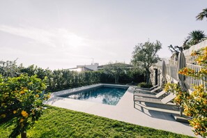 A rectangular swimming pool with a surrounding deck, a stone wall, and a clear sky. - Villa "Cavalino Boutiquehouse" with Lake View, Pool & Wi-Fi (Cavaion Veronese)