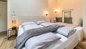Ein Schlafzimmer mit Bett, Nachttischlampen, einem Nachttisch und einem Spiegel.