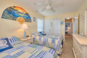 Relax in this serene suite with a comfortable bed, bedside table, and ceiling fan.