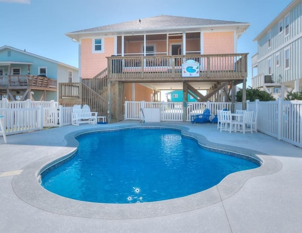 Guests can enjoy a balcony with a pool view, surrounded by a white picket fence.
