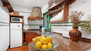 Una cocina con microondas, refrigerador, fregadero y un bol de limones en la encimera.