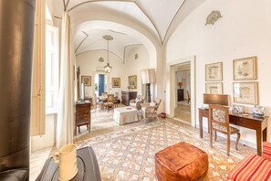 A spacious living area with a patterned floor, a coffee table, a sofa, a desk, and a chair. - Villa 'Luisa' with Sea View, Wi-Fi, and Air Conditioning (Leuca)