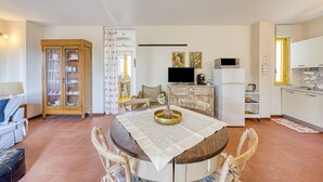 A compact living space with a dining area, kitchen, and a small seating area.
