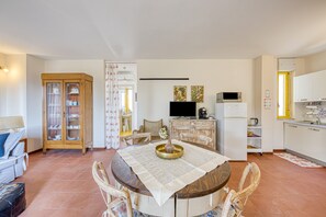 A compact living space with a dining area, kitchen, and a small seating area.