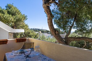 Un balcon avec une table dressée pour le dîner, offrant une vue sur le paysage urbain.