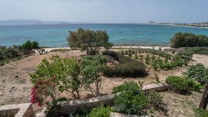 A coastal landscape with a sandy area, trees, and a view of the sea and distant mountains. - Vacation Home "On a Magnificent Sandy Beach" with Sea View, Terrace & Wi-Fi (Naxos)