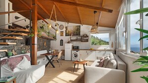 A spacious living area with a sofa, dining table, and kitchen area with a view. - Holiday Home "Tajaraste 2" with Sea & Mountain Views, Private Terraces & Wi-Fi (Hermigua)