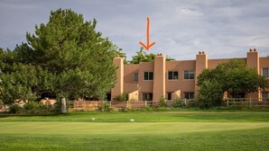 Een golfbaan met een gebouw op de achtergrond.