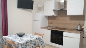 Una cocina compacta con lavamanos, cocina y un refrigerador pequeño.