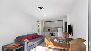 A modern living room with a sofa, dining table, and chairs. - Vacation Home "Arcadia T3" with Private Pool, 2 Terraces & Wi-Fi (São Bartolomeu de Messines)