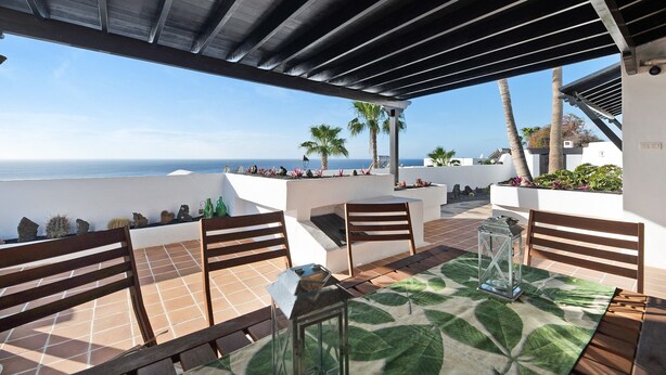 An outdoor patio with a table, chairs, and a lantern. - Vacation Home "Los Angeles" with Sea View, Private Terrace & Wi-Fi (Tías)