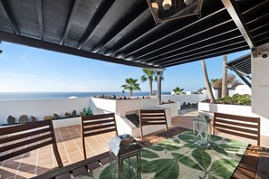 Une terrasse extérieure avec une table, des chaises et une lanterne.