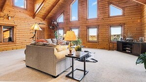 A log cabin interior with a sofa, lamps, a cowhide rug, and a desk. - Sky Creek Ranch Montana  Lodge House
 (Molt)