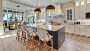 A spacious kitchen with a large island, modern appliances, and ample natural light from large windows. - New Oceanfront Oasis in Palmetto Dunes with a private pool and EV plug (Hilton Head Island)