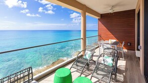 A balcony with a clear view of the ocean, wicker chairs, and a table. - SeaDreams 5: Oceanfront Condos w/Pool, Hot Tub, & Rooftop Patio (West Bay)