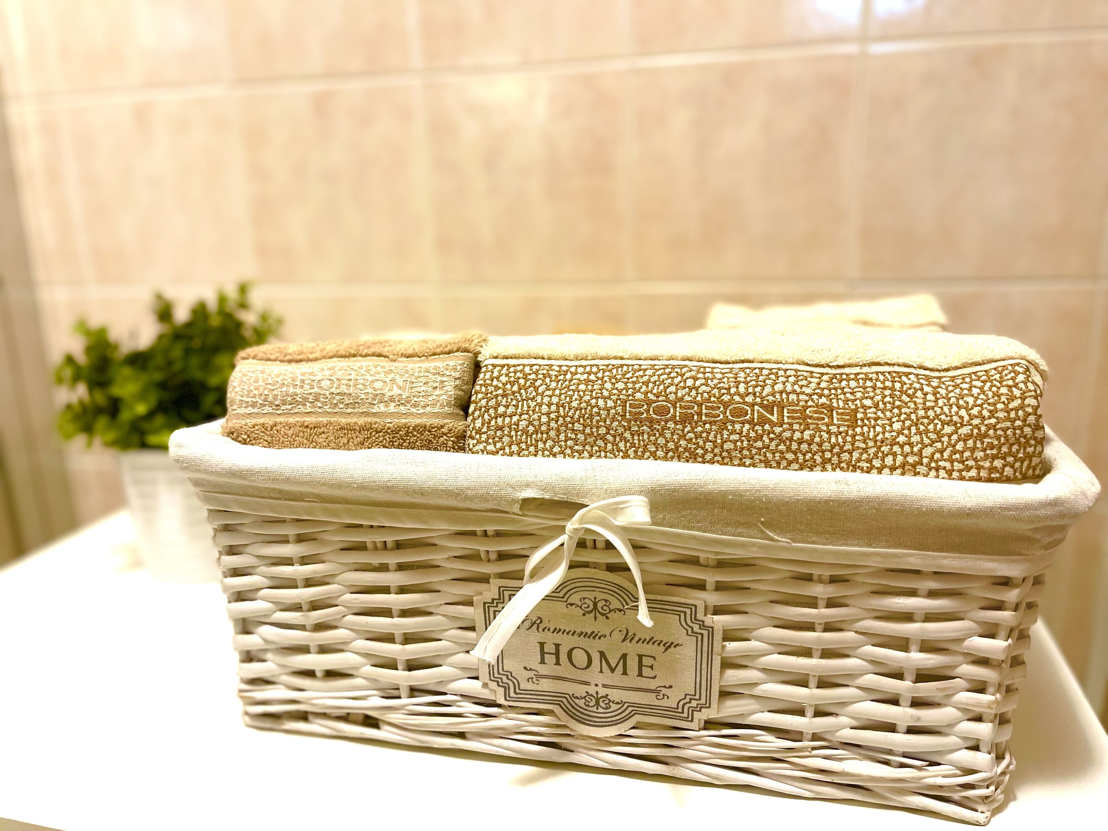 Ein Korbwäscher mit einem Schild mit dem Aufdruck 'HOME' und einem gefalteten Handtuch.