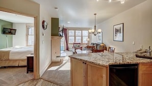 A spacious living area with a kitchen island, a dining table, and a comfortable seating arrangement. - Silver Mill 8167-1br-walk To Slopes! Kids Ski Free! 1 Bedroom Condo by RedAwning (Keystone)
