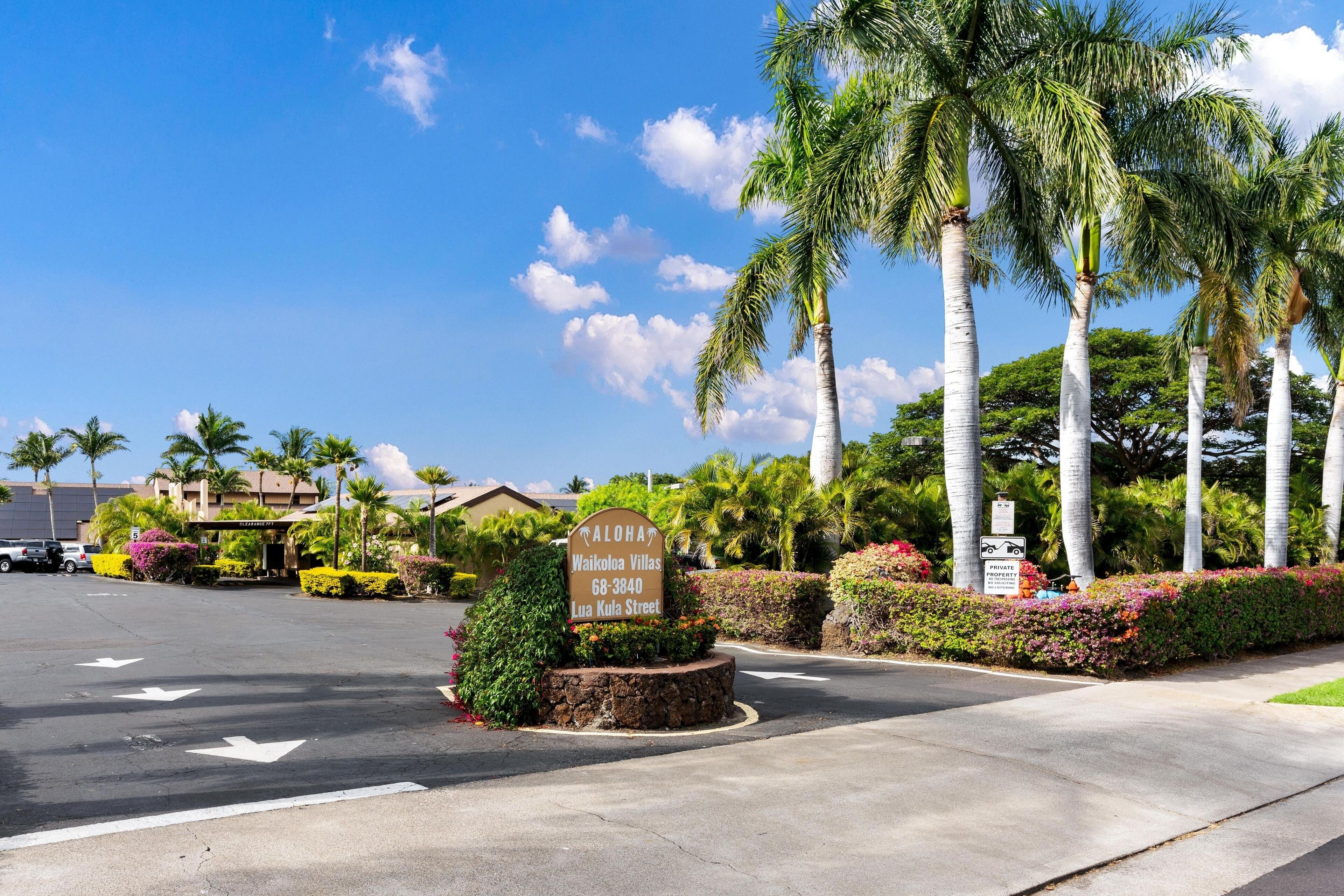 En skylt för Waikoloa Villas på Lua Kula Street, med palmer och en klar himmel i bakgrunden.