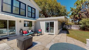 Relax in a serene outdoor space with a patio featuring a seating area, wicker chairs, and a covered table.