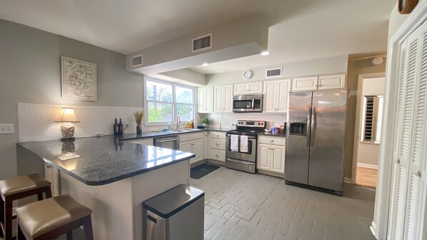 Enjoy cooking in this kitchen with a central island, seating, and stainless steel appliances.