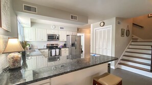 Enjoy cooking in this well-equipped kitchen with a central island, stainless steel appliances, and white cabinetry.