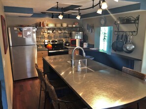 Enjoy cooking in this well-equipped kitchen with a sink, refrigerator, and microwave.