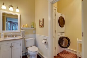 Een bad/douchecombinatie, een haardroger, handdoeken