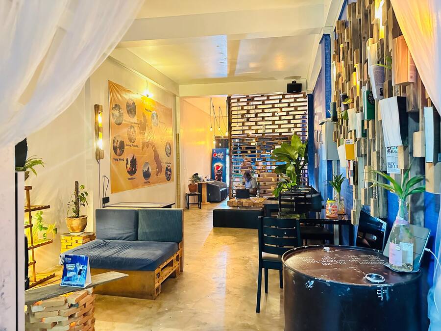 Un espacio lounge moderno y acogedor con un sofá, una mesa de centro y una pared de madera con varios objetos.