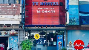 A hostel with a prominent red facade and a blue sign indicating its name. - TT Hostel (Vientiane)