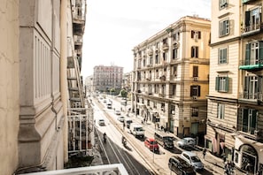 A street view with multi-story buildings, a busy road, and a clear sky. - Maison Maria Marì (Napoli)