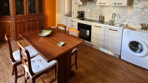 Una cocina moderna con armarios de madera, horno empotrado y lavadora.
