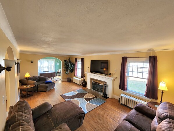 A living room with a fireplace, a television, and a sofa.