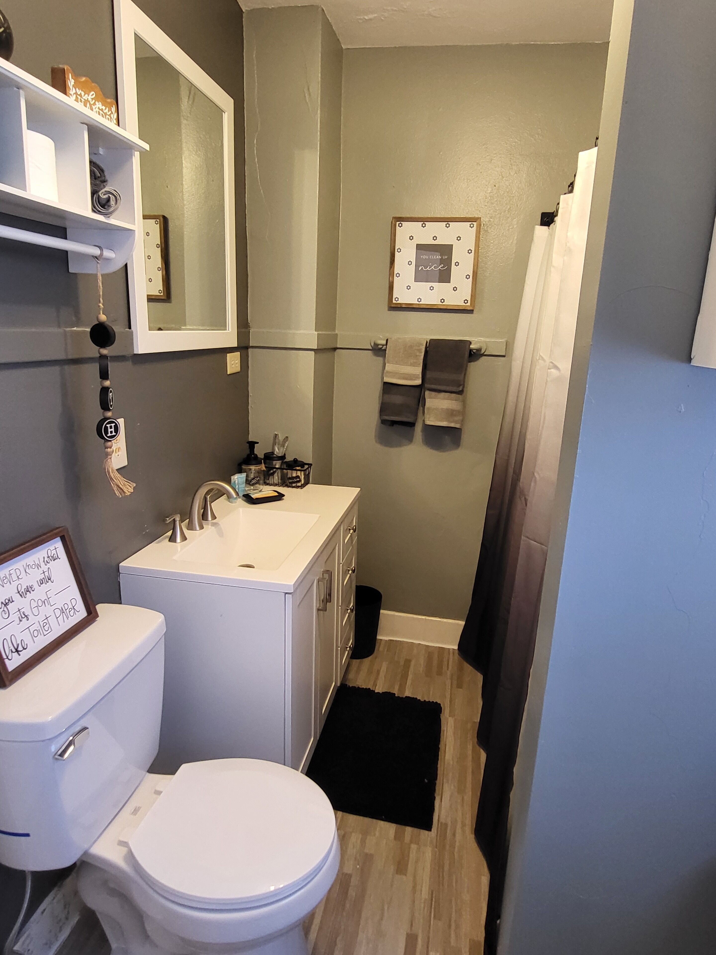 Une petite salle de bain comprenant des toilettes, un lavabo et un espace douche.