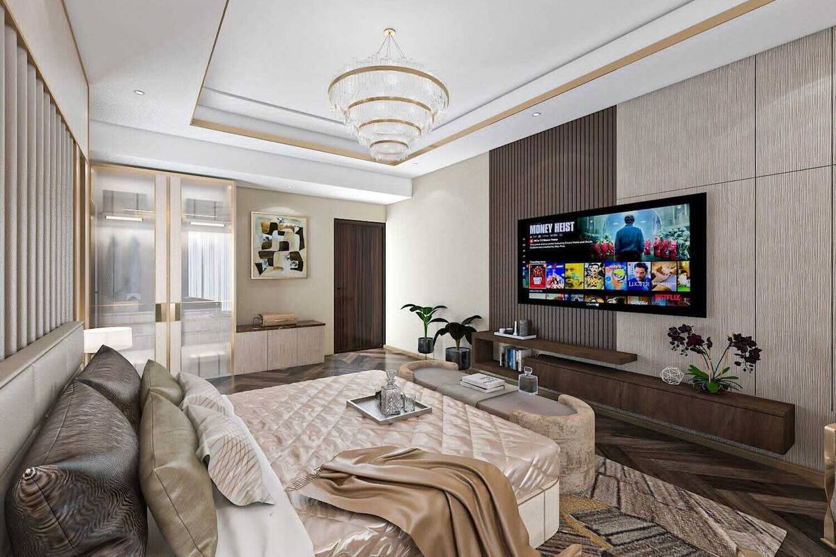 A modern bedroom with a large TV, a sofa, a bed, and a decorative plant.