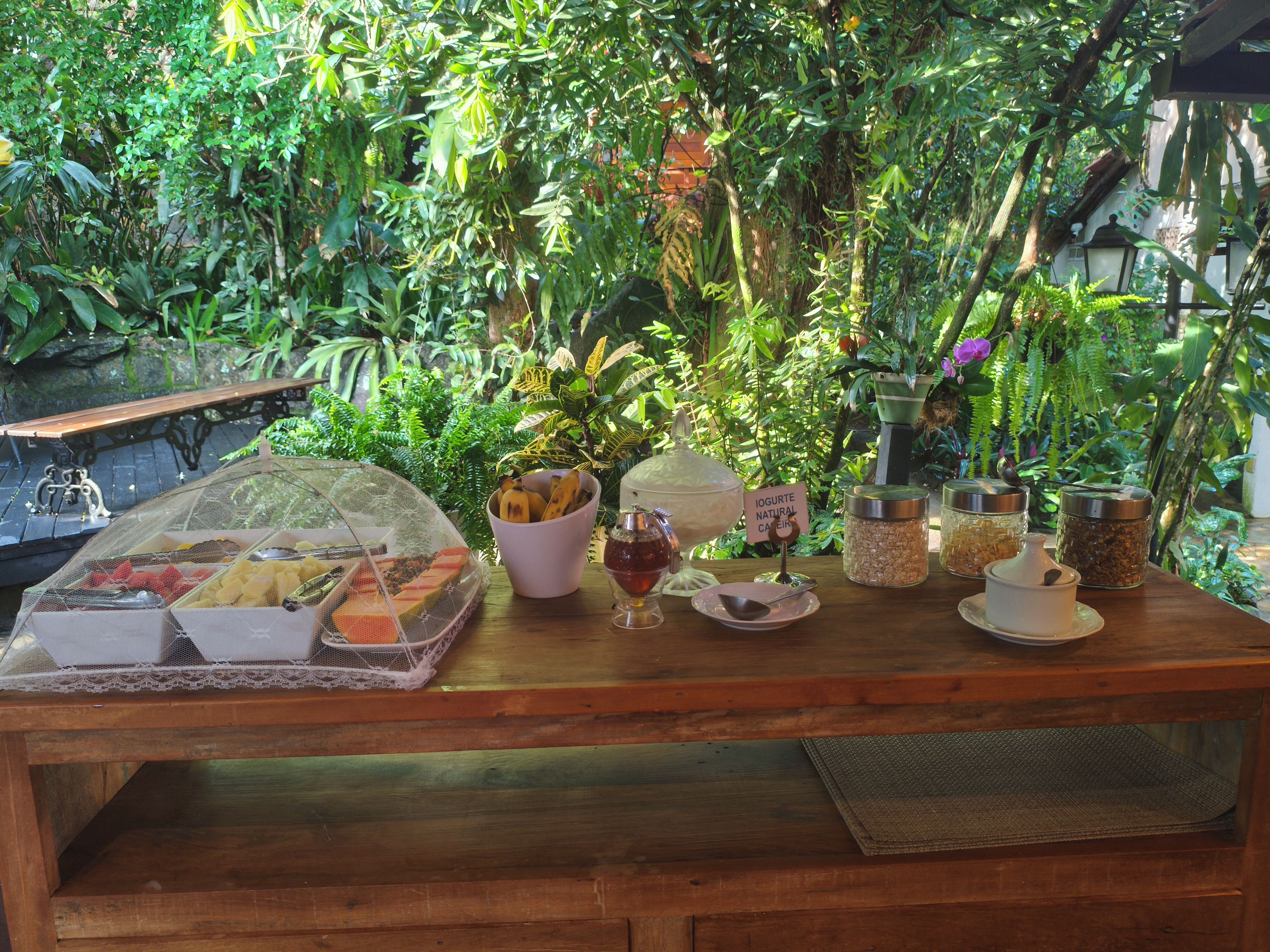 Une table en bois sur laquelle sont disposés divers aliments, ainsi qu’un panneau indiquant la présence de yaourt nature.
