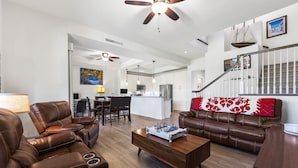 A spacious living room with leather sofas, a wooden coffee table, and a ceiling fan. - Private Mauna Lani Residence with Pool (Kamuela)