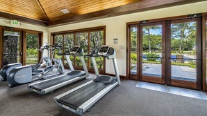 A gym with treadmills, ellipticals, and a stone wall. - Private Mauna Lani Residence with Pool (Kamuela)