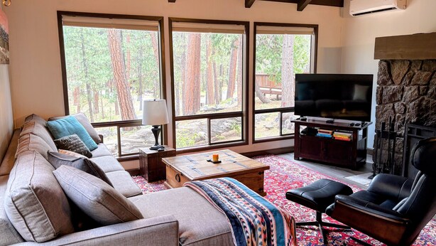 Una sala de estar con sofá, mesa de centro, televisor y chimenea.