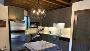 Una cocina moderna con horno empotrado, microondas y refrigerador de acero inoxidable.