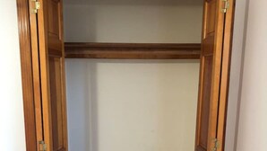Un vestidor con estructura de madera, un espejo plano y un calentador incorporado.