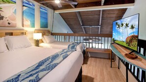 A hotel room with two beds, a ceiling fan, a TV, and artwork on the walls.